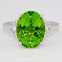 Platinum oval cut peridot and graduated round brilliant cut diamond ring