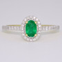 18ct gold emerald and diamond halo ring with diamond-set shoulders