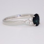 Platinum oval cut teal sapphire and round brilliant cut diamond ring side