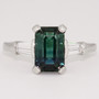 Platinum emerald cut teal sapphire and tapered baguette diamond ring