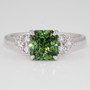 Platinum radiant cut green sapphire and six round brilliant cut diamond ring