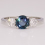 Platinum round cut teal sapphire and round brilliant cut diamond ring