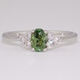 Platinum oval cut green sapphire and round brilliant cut diamond ring
