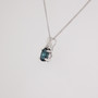 9ct white gold oval cut teal sapphire and diamond swirl pendant side