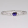 Platinum rubover-set sapphire ring with diamond-set shoulders