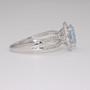 Platinum oval cut aquamarine and round brilliant cut diamond halo ring with open diamond-set shoulders side