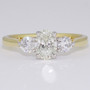 18ct gold and platinum ring with a certificated oval cut diamond and two round brilliant cut diamonds