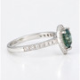 Platinum pear cut unheated Madagascan teal sapphire and round brilliant cut diamond halo ring with diamond-set shoulders side