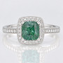 Platinum cushion cut Madagascan teal sapphire and round brilliant cut diamond halo ring with diamond-set shoulders