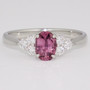 Platinum oval cut raspberry sapphire and round brilliant cut diamond ring