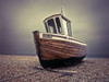 Boat moored on pebbled Beach Poster Print by  Assaf Frank - Item # VARPDXAF20100407004C06