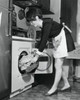 Side profile of a young woman putting clothes into a dryer Poster Print - Item # VARSAL25541876