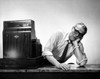 Senior man leaning over a checkout counter near a cash register in a store Poster Print - Item # VARSAL25520234