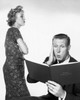 Close-up of a young man looking surprised while reading a budget book and a young woman standing beside him Poster Print - Item # VARSAL25519153C