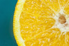 Studio shot of an orange half on a blue background. PosterPrint - Item # VARDPI2116540