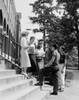 Five students standing on steps in front of university building and talking Poster Print - Item # VARSAL255419269