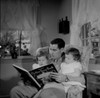 Father reading to daughters in living room Poster Print - Item # VARSAL255417023
