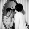 Young woman putting make-up on in front of mirror Poster Print - Item # VARSAL255417739