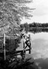 Boy sitting on jetty and fishing Poster Print - Item # VARSAL255416992