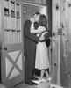 Mid adult couple kissing each other in a doorway Poster Print - Item # VARSAL25550164