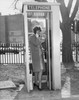 Side profile of a young woman talking on the phone in a telephone booth Poster Print - Item # VARSAL25533649
