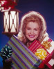 Portrait of a mature woman holding Christmas presents and smiling Poster Print - Item # VARSAL3824392397