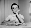 Thoughtful boy sitting with open book and looking away Poster Print - Item # VARSAL255417777