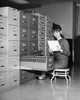 Businesswoman reading a document beside a filing cabinet Poster Print - Item # VARSAL25548498