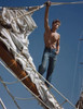 Low angle view of a young man standing on a pole on a sailing ship Poster Print - Item # VARSAL384418592