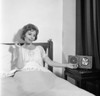 Portrait of mid adult woman reclining in bed and listening to the radio Poster Print - Item # VARSAL255420777