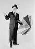 Man in suit holding umbrella and checking for rain Poster Print - Item # VARSAL255419053