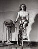 Young woman exercising on an exercise bike Poster Print - Item # VARSAL2553675
