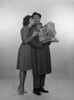 Woman kissing laughing man holding gifts  studio shot Poster Print - Item # VARSAL255417362