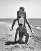 Young couple playing leapfrog on the beach Poster Print - Item # VARSAL2558794