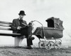 Father sitting on a bench holding a baby carriage Poster Print - Item # VARSAL2559755