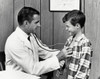 Male doctor examining a boy with a stethoscope Poster Print - Item # VARSAL25512456