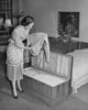 Side profile of a young woman putting clothes in a cedar chest Poster Print - Item # VARSAL25542005