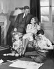 Mid adult couple with their two children in a living room Poster Print - Item # VARSAL25513273B