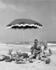 Mid adult couple with two children at picnic on beach Poster Print - Item # VARSAL2553142B