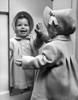 Girl looking at her reflection at mirror and laughing Poster Print - Item # VARSAL255416569