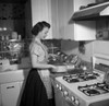 Young woman cooking in kitchen Poster Print - Item # VARSAL25535481