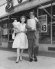 Mid adult couple carrying shopping bags in front of a store Poster Print - Item # VARSAL25543748