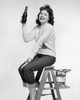 Portrait of a young woman sitting on a step ladder and holding a bottle of beer Poster Print - Item # VARSAL25512674