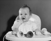 Baby girl sitting in a high chair with her finger in her mouth Poster Print - Item # VARSAL2559708