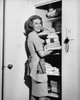 Portrait of a young woman putting towels in a cabinet Poster Print - Item # VARSAL255401