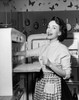 Portrait of a young woman standing near a refrigerator Poster Print - Item # VARSAL2554588