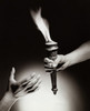 Close-up of a person's hand passing a flaming torch to another person Poster Print - Item # VARSAL2553646