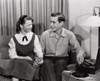 Young couple sitting on sofa near record player Poster Print - Item # VARSAL2557545