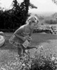Small girl watering flower in garden Poster Print - Item # VARSAL255416372