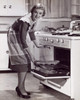 Portrait of a young woman putting food into an oven Poster Print - Item # VARSAL2552879